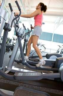 Woman working out on an elliptical trainer at the gym