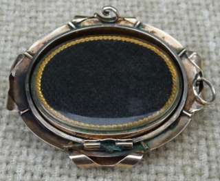 The locket / brooch has a central glass spinner which is inset with 